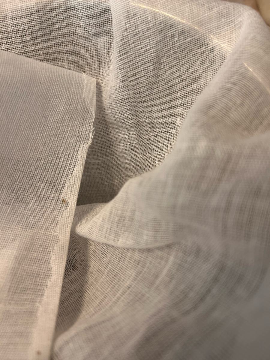 Folds of fine white muslin cloth, the donated cloths used to strain this batch